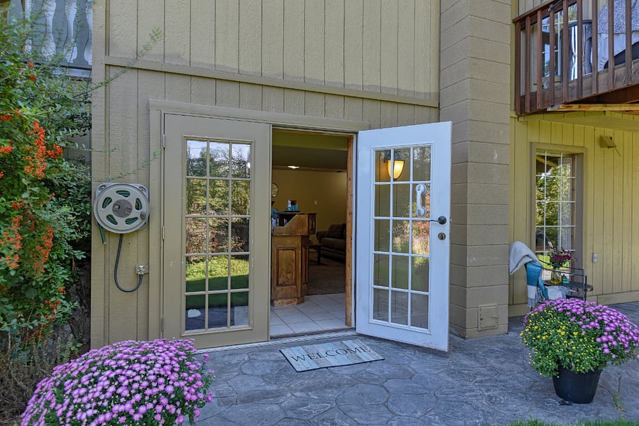 Private French doors open to a bright patio and landscaped yard, offering a cheerful and inviting hello each time you come and go.