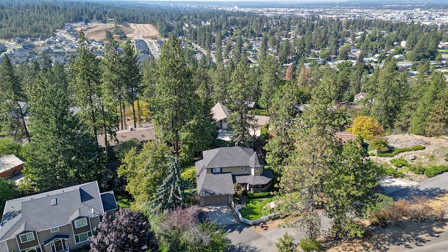 Aerial view captures the charming, peaceful neighborhood on a quiet dead-end street, with city and surrounding area vistas. Just beyond the property, the Dishman Mica Nature Reserve offers a short stroll to tranquil trails and natural beauty, perfect for unwinding after a busy day.