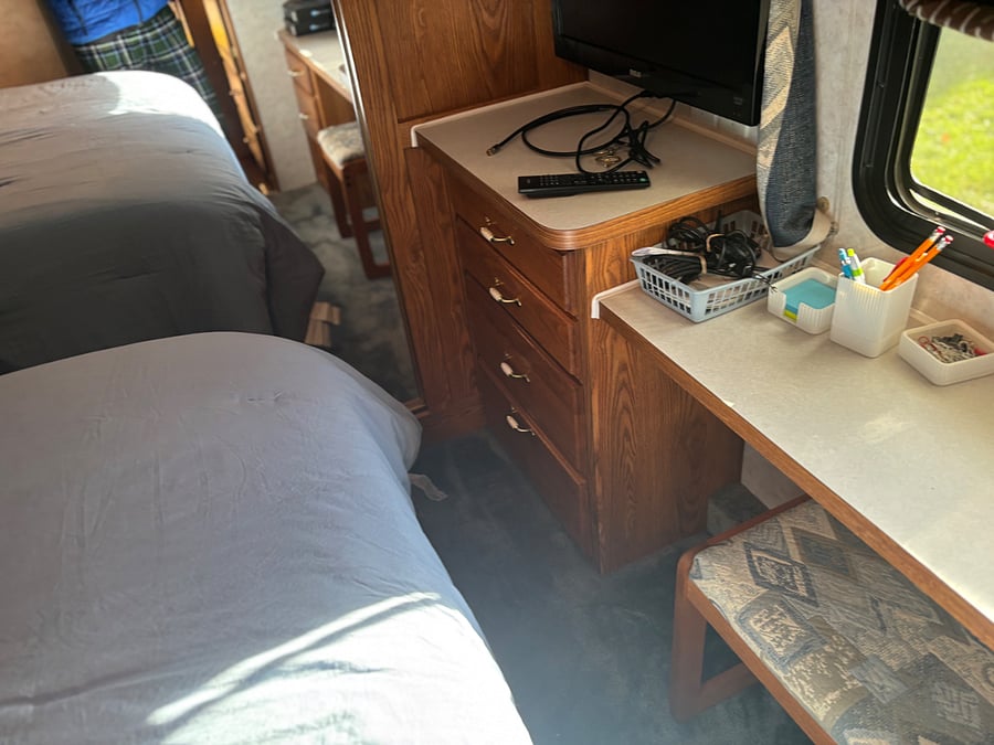 desk at the end of the bed by the window in the bedroom