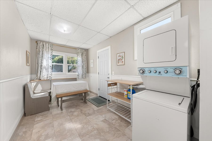 dining/laundry room with a stacked washer & dryer set; includes back door exit into backyard