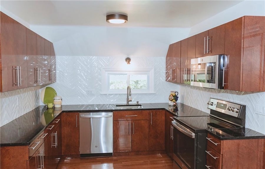 Large kitchen with new cabinets and stainless steel appliances.