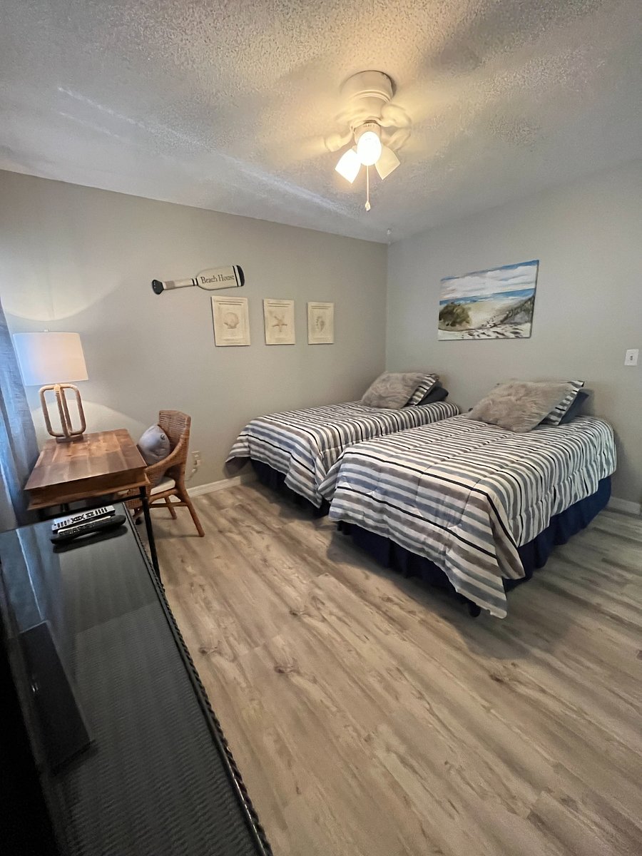 Guest room with two twin beds, a dresser and a desk.