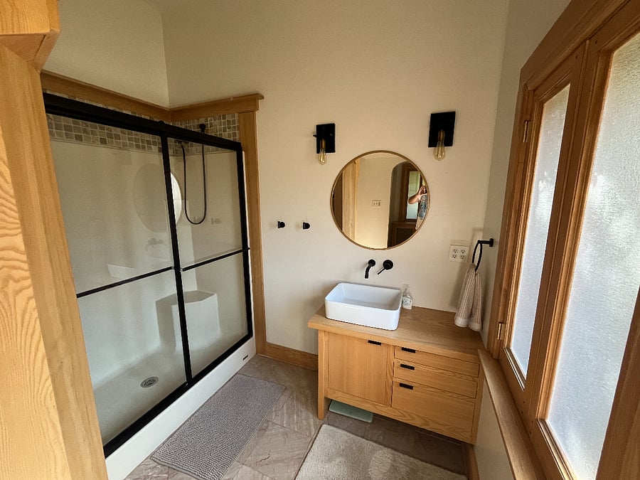 Main bathroom is updated with dual-head shower, heated bathroom floors, and custom-built woodwork