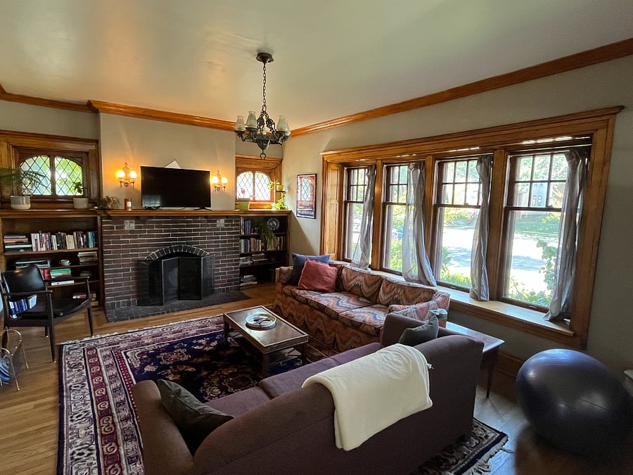 Massive living room with Roku-enabled TV, lighting fast wi-fi, comfy couches, library, beautiful fireplace mantle, and leaded glass windows