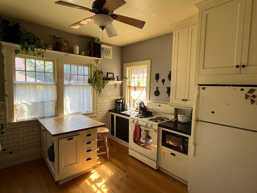 Sunny kitchen features kitchen island with room to dine, gas stove/range, new dishwasher, microwave and TONS of storage space