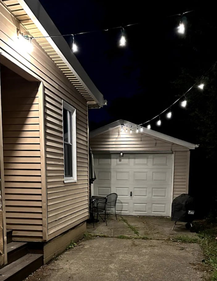 Patio lights and seating with table at end of driveway 