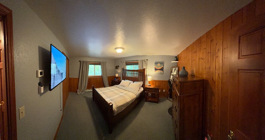 Our natural wood guest room with a queen bed and dresser is spacious and comfortable