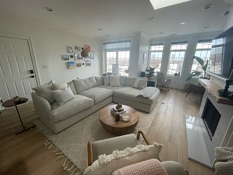 Couch and fireplace in the living area. Desk setup in the nook behind