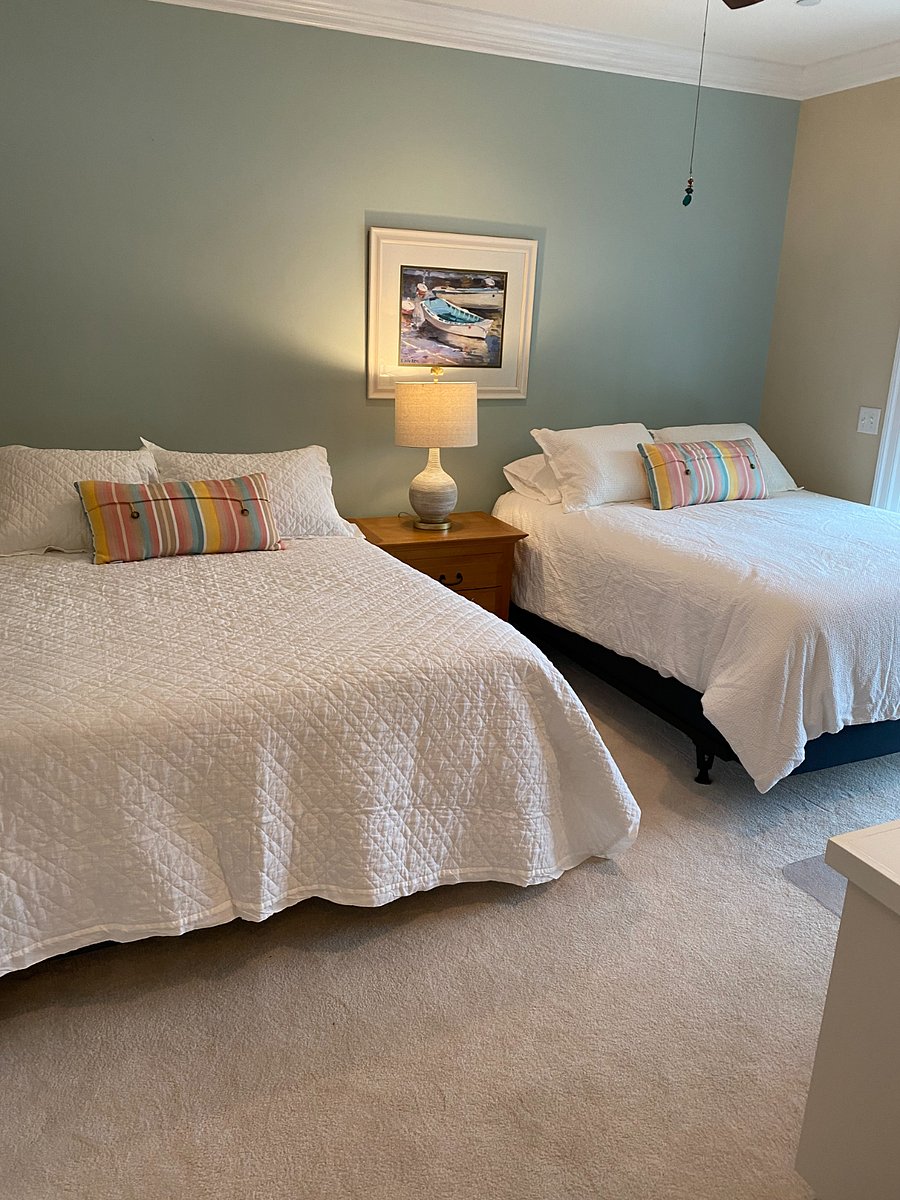 A bedroom with two Queen beds with a built-in desk.