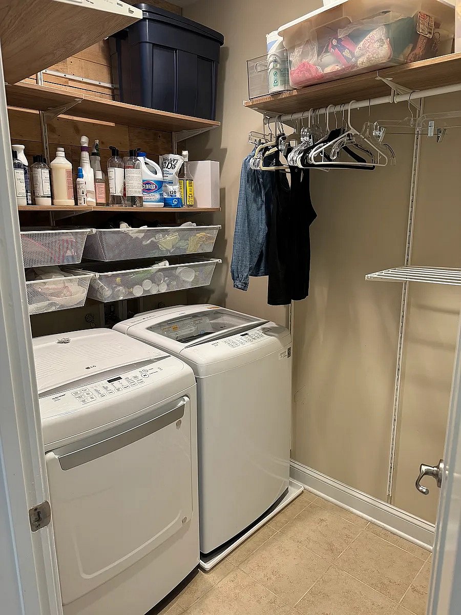 Laundry room with washer/dryer, ironing board, and drying racks.