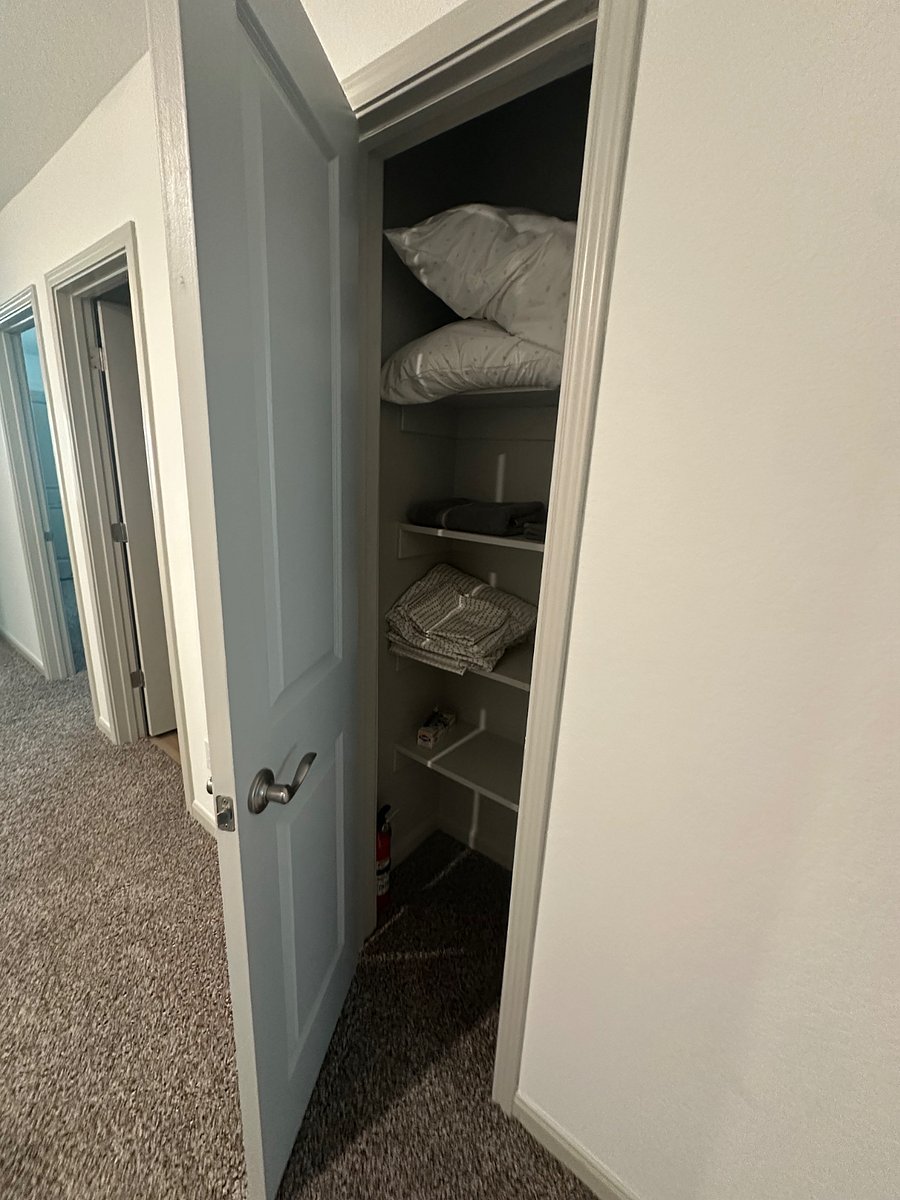 Hallway linen closet between shared bath and master bedroom. A fire extinguisher is located here.