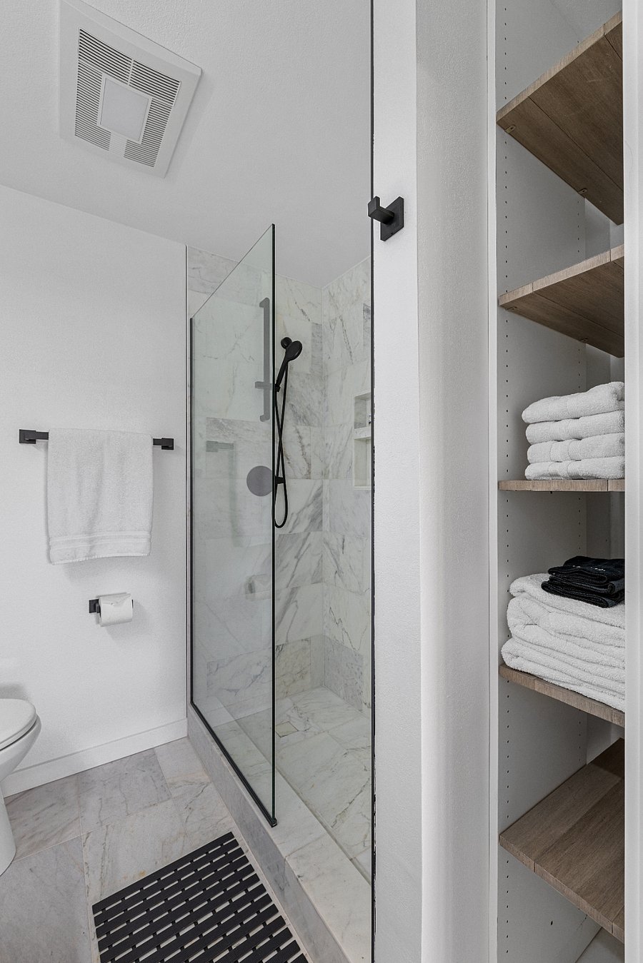 Carrera marble shower and bath towels with storage area.