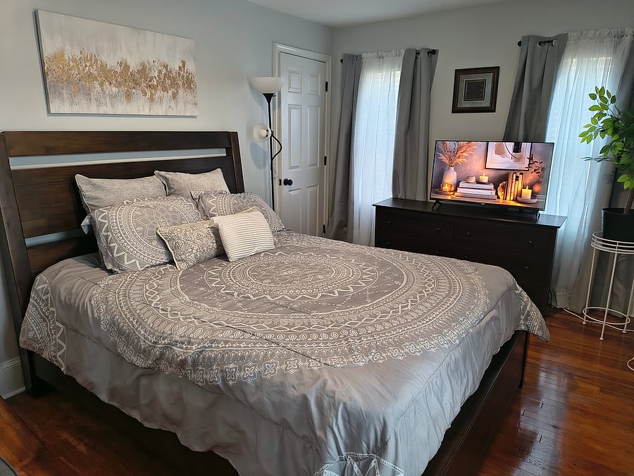 Primary bedroom with queen bed and 40 inch smart tv.