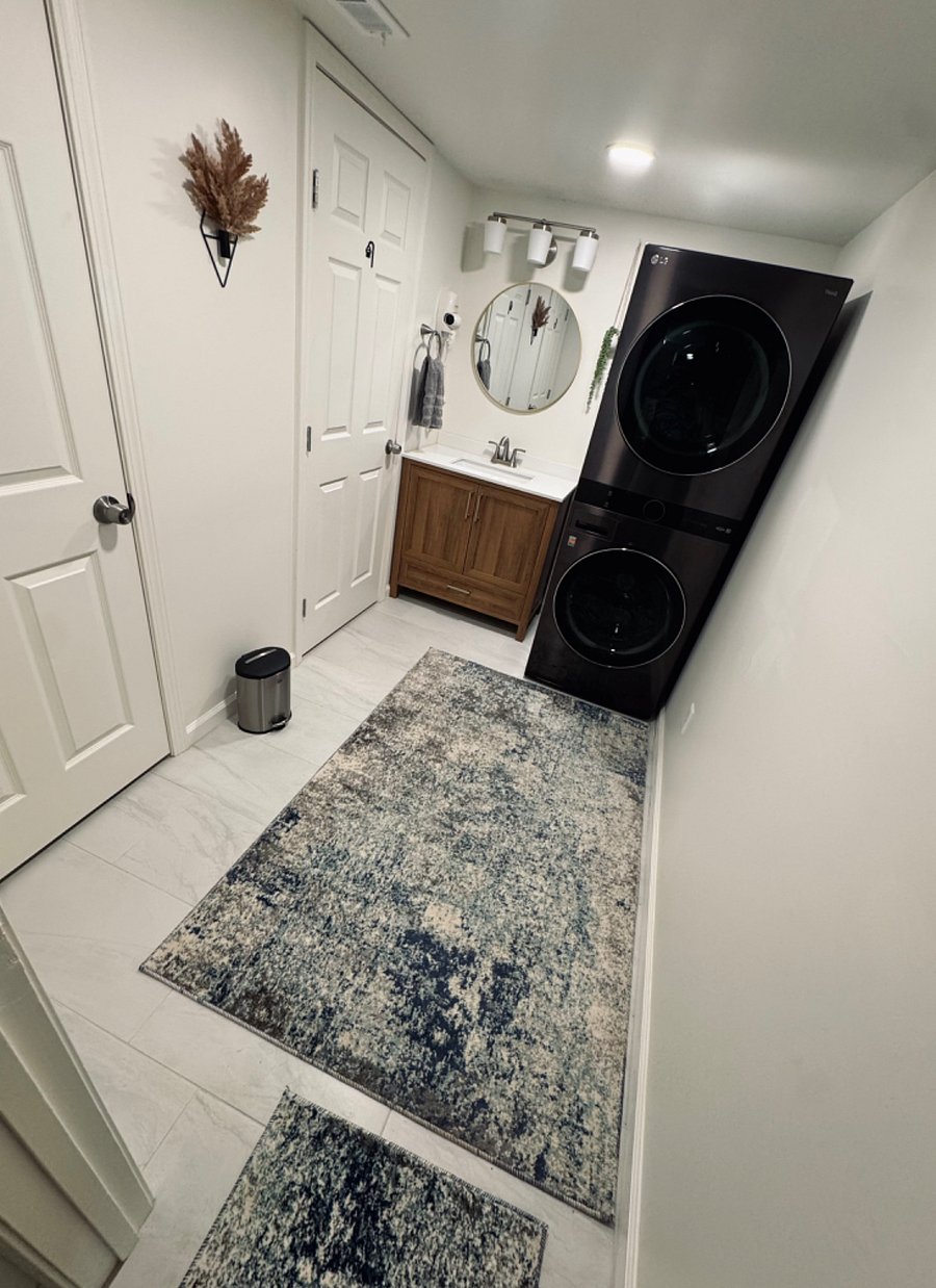 Wet room area: first door on the left is the toilet water closet and the second door is a stand alone shower. Featured here is the bathroom sink and washer and dryer.
