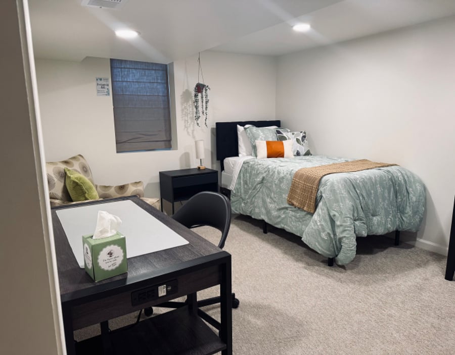 Northern Gate Bedroom with nightstand, full closet (not pictured), hangers, desk, comfy chair and dresser. Egress window emergency exit. Power-touch nightstand light with charging port. Twin bed. Blackout curtain.