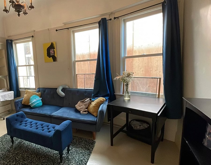 Living room and dining table, with blackout curtains and bookshelf.