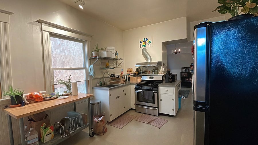 Kitchen angle from the back of house with view of appliances and storage areas.