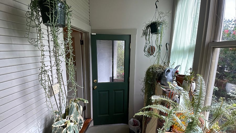 Sun room at the back of the house with extra storage and the door to the porch and backyard.