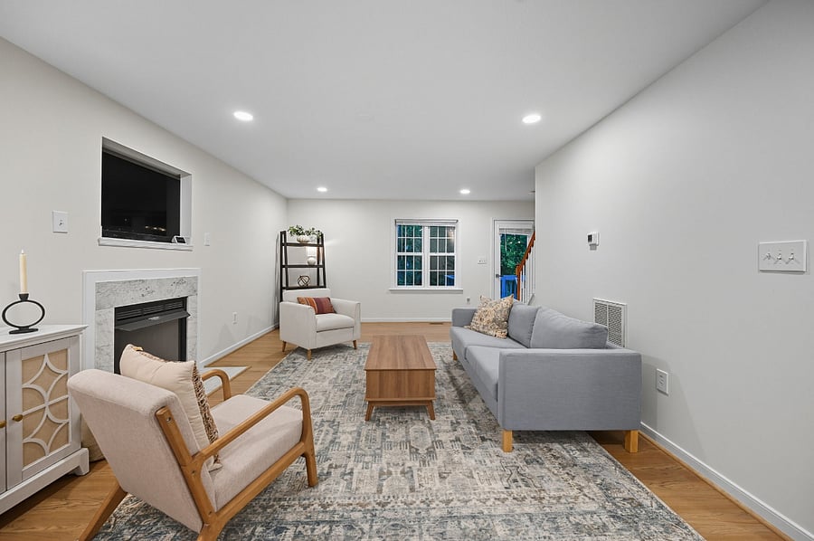Comfortable living room with sofa, armchairs, fireplace, and smart TV. Designed for relaxation after long shifts or workdays.