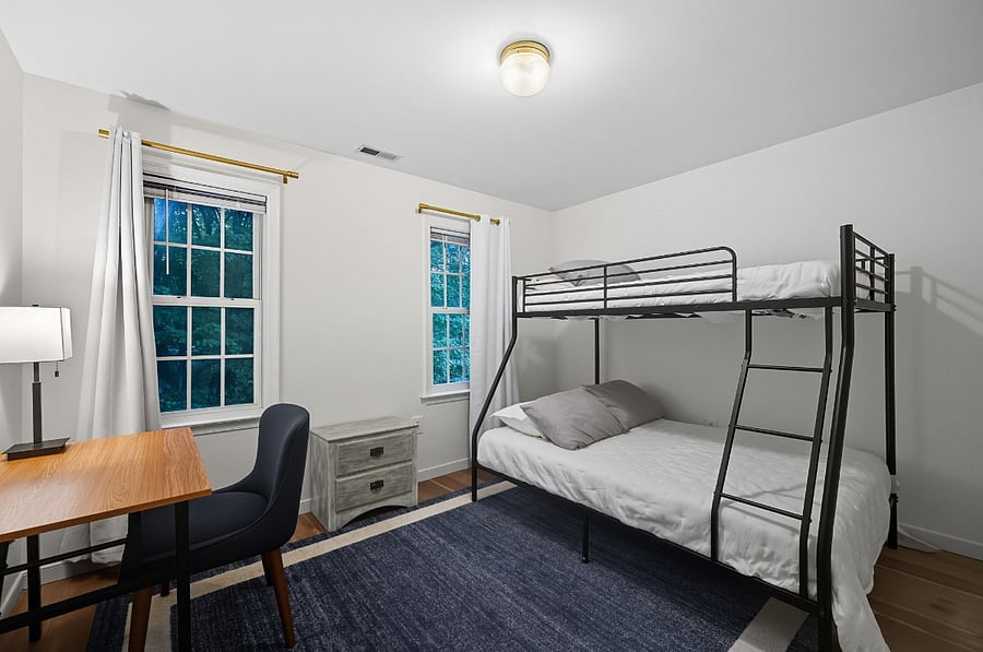 Bedroom with full/twin bunk bed and desk  functional for guests, colleagues, or family.