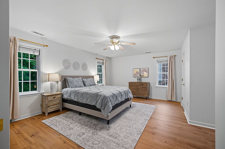 Large secondary bedroom with queen bed, ceiling fan, desk, dresser, and nightstands. Comfortable and quiet for extended stays.