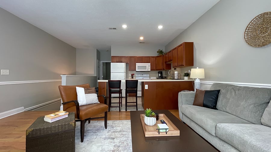 eel at ease in our cozy living room, featuring a plush couch and a view of the sleek kitchen-perfect for your getaway!