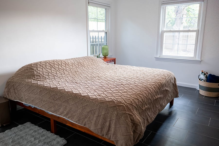 Second bedroom, two closets with automatic lighting when you open the door, 3 windows, king sized memory foam mattress, bedstand, table lamp (cactus), chair, artwork