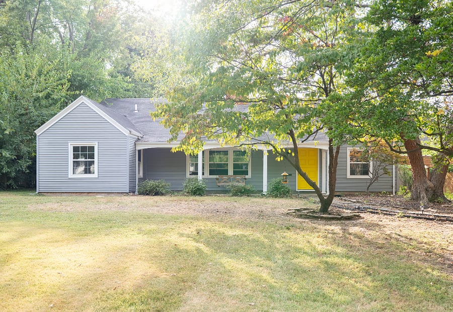 Front of the house. Porch swing and long driveway with car port
