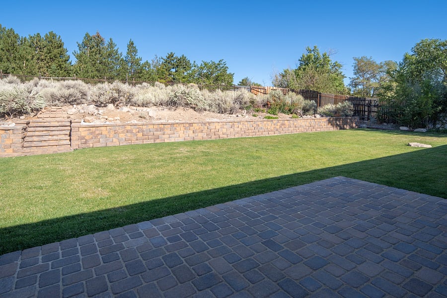 Private backyard with wrap around paver patio for entertaining and relaxation. Grass is professionally maintained.