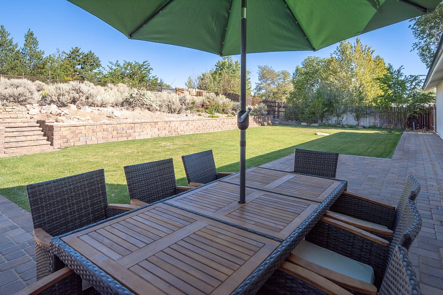 Private backyard with wrap around paver patio for entertaining and relaxation. Grass is professionally maintained.