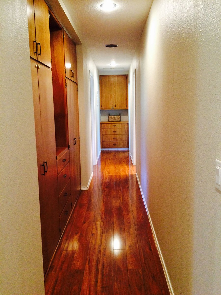 Hallway leading to bedrooms with closets filled with linens, towels, games, extra blankets, pillows, cleaning supplies, etc.