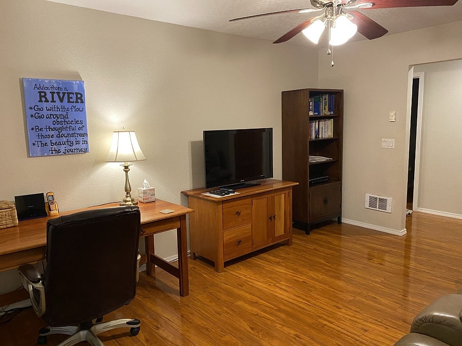 Family room with work area, smart TV, and lots of great reading on the bookshelf.