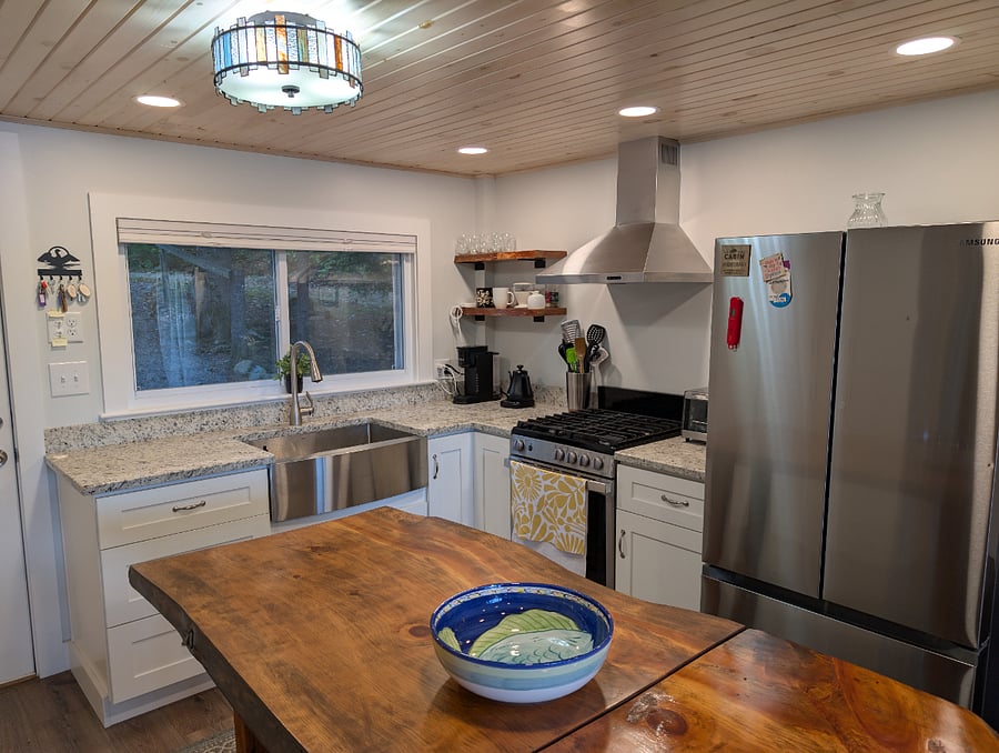 Fully equipped modern kitchen with pots, pans, utensils, coffee pod machine, and more. 