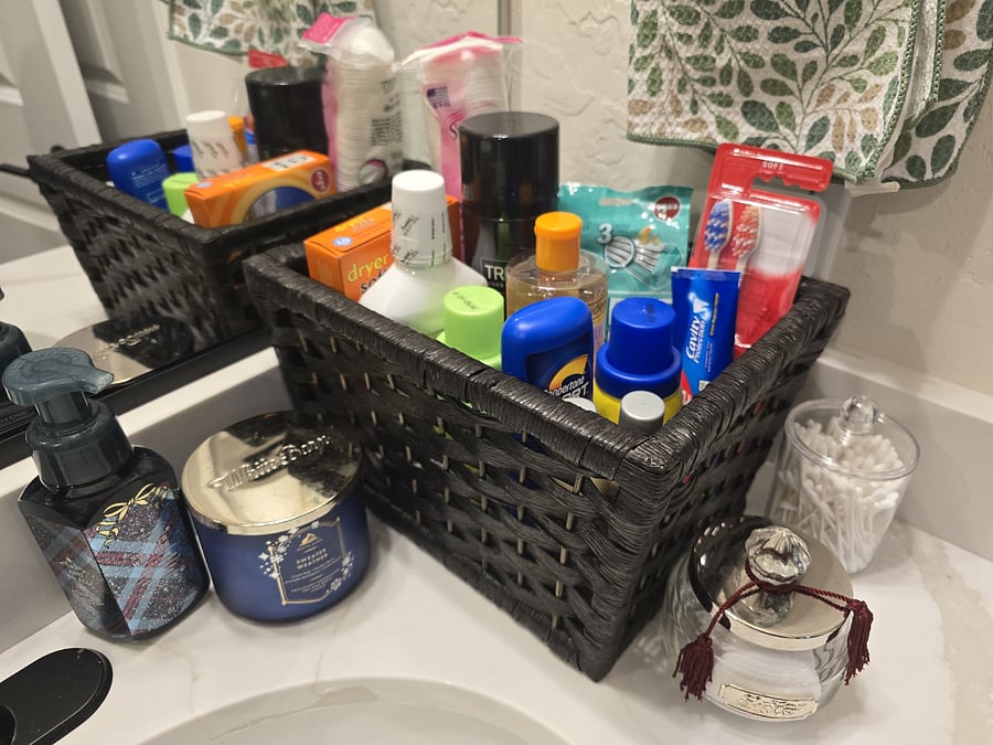 One-Time Bathroom Basket
Guests are welcomed with a one-time supply of personal care basics, thoughtfully arranged to cover common needs and forgotten items. The basket includes sunscreen, mouthwash, toothpaste, toothbrushes, cotton swabs, and a few extras to help guests settle in comfortably. Items are organized in black woven baskets for a tidy, easy-to-browse setup. A candle adds a soft touch, and the selection is designed to be useful without overwhelming. Its a simple amenity that reflects care and attention to detail.