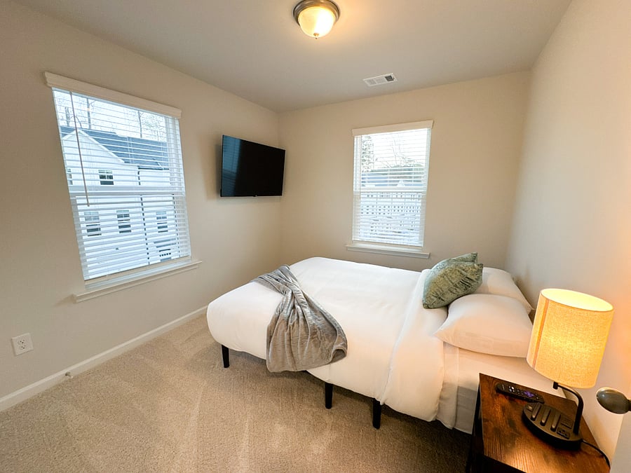 Bedroom 3 with an adjustable queen bed, Smart TV, and a spacious closet with hangers for your convenience
