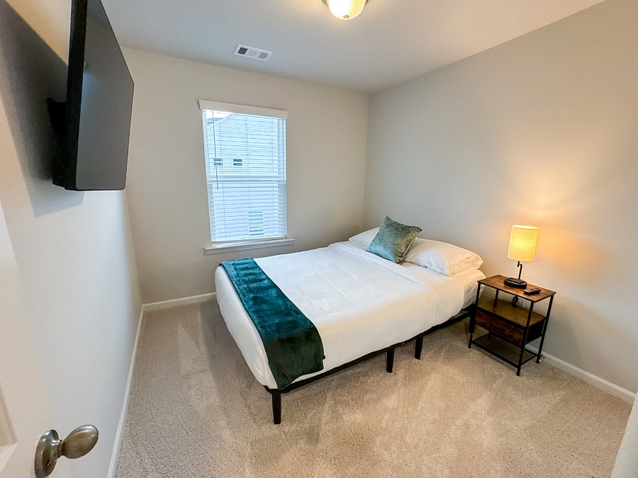 Bedroom 2 with an adjustable queen bed, spacious closet, and Smart TV for ultimate comfort and convenience

