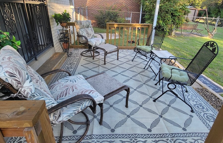 Fenced in backyard with covered patio seating. Which offers comfort and relaxation on either sunny or rainy days