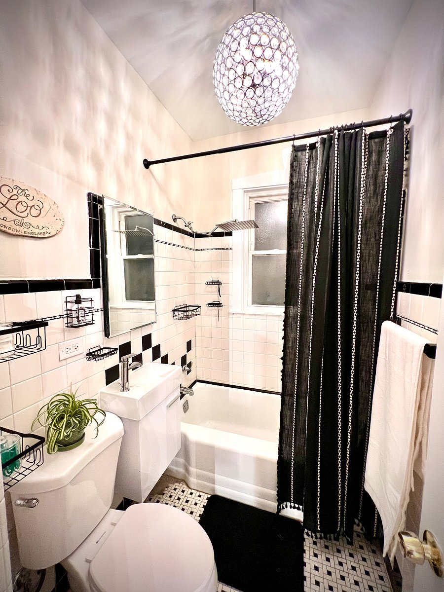 The art deco black and white bathroom. Tub/Shower has a rainfall attachment making the morning shower feel like heaven. Though this old style bathroom didn't have lots of room for toiletries and other items we typically want to spread out, we have affixed metal shelving on the tiles of the bathroom both on the outside of the shower and on the inside. There is now plenty of places to store things.
In the kitchen in the green free standing closet, you'll find sheets and towels as well as a generous starter kit of bathroom essentials: shampoo, body wash, body lotion, a face mask for men, q-tips, makeup removal pads, etc. We hope this make your stay easier.