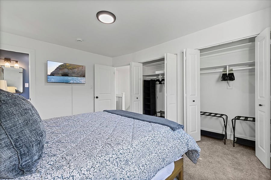 Primary bedroom has two closets with organizers and extra bedding.