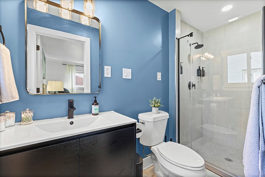 Primary suite bathroom has glass door and beautiful tiled shower.