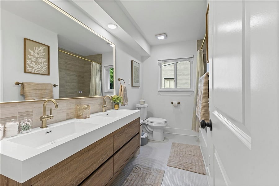 Stunning full hallway bathroom with tiled shower and bathtub, lighted mirror and plenty of towels!