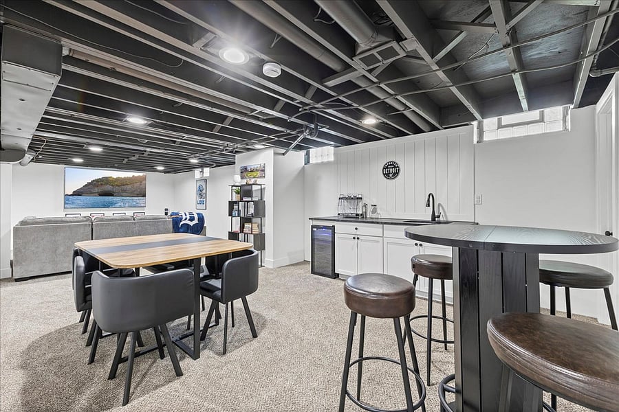 The fun room in the basement with an 85" TV, Bose sound bar, kitchenette, dining table, pub table, Detroit themed games and more!