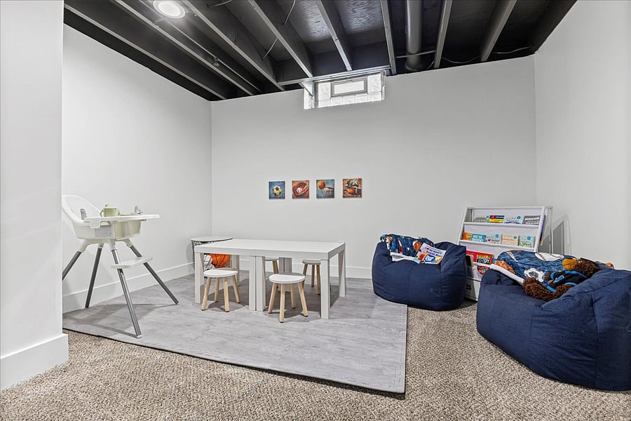 Kids' corner with table, stools, book shelf, books, bean bags, blankets and a high chair to use wherever you may need it.