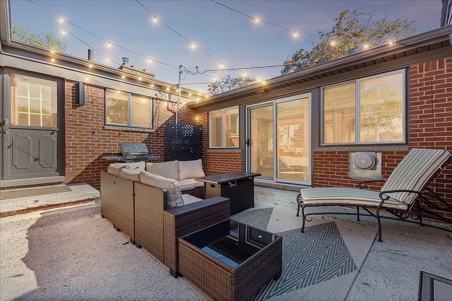 Private patio with grill, seating, fire table and string lights is the perfect space to relax outdoors.