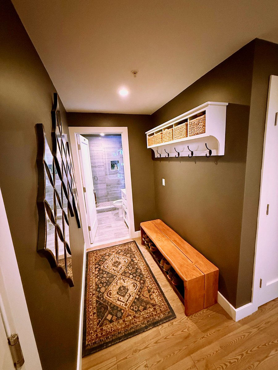 Mud room area with hooks and storage baskets, plus a beautiful live edge bench with a shelf for shoes.  