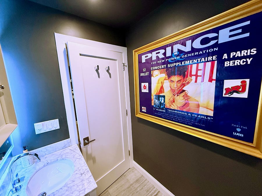Another view of the second bathroom from the inside.  Gorgeous large framed poster of a vintage Prince concert posting from Paris.