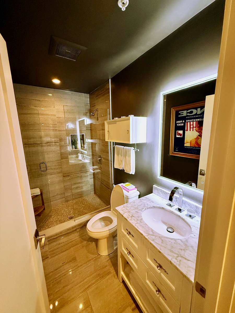 The second bathroom.  Urbane bronze finishings, a glassed-in marble shower, and ample storage.