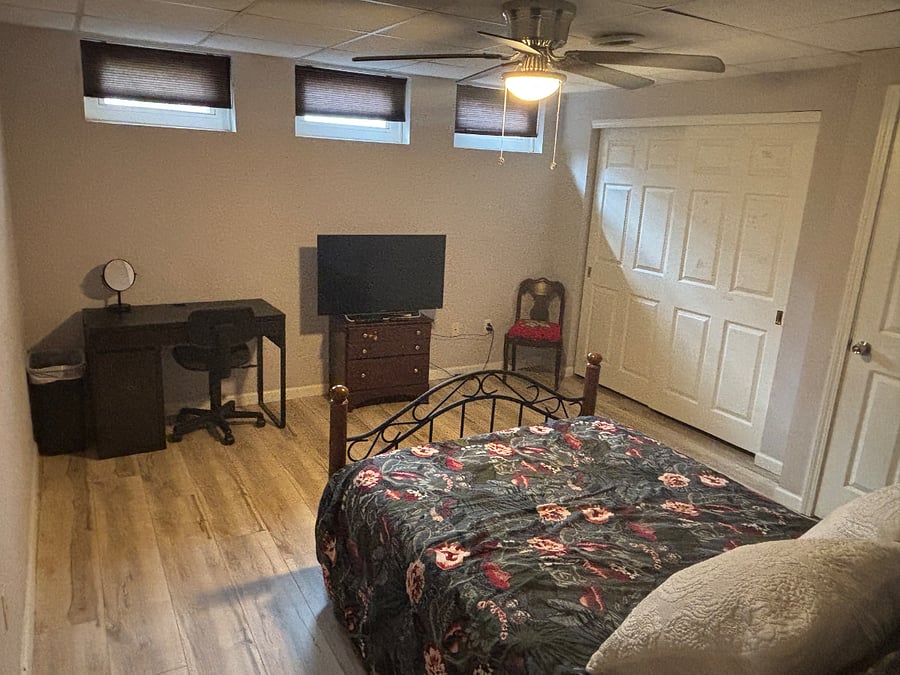 Bedroom has large reac-in closet, desk and smart TV