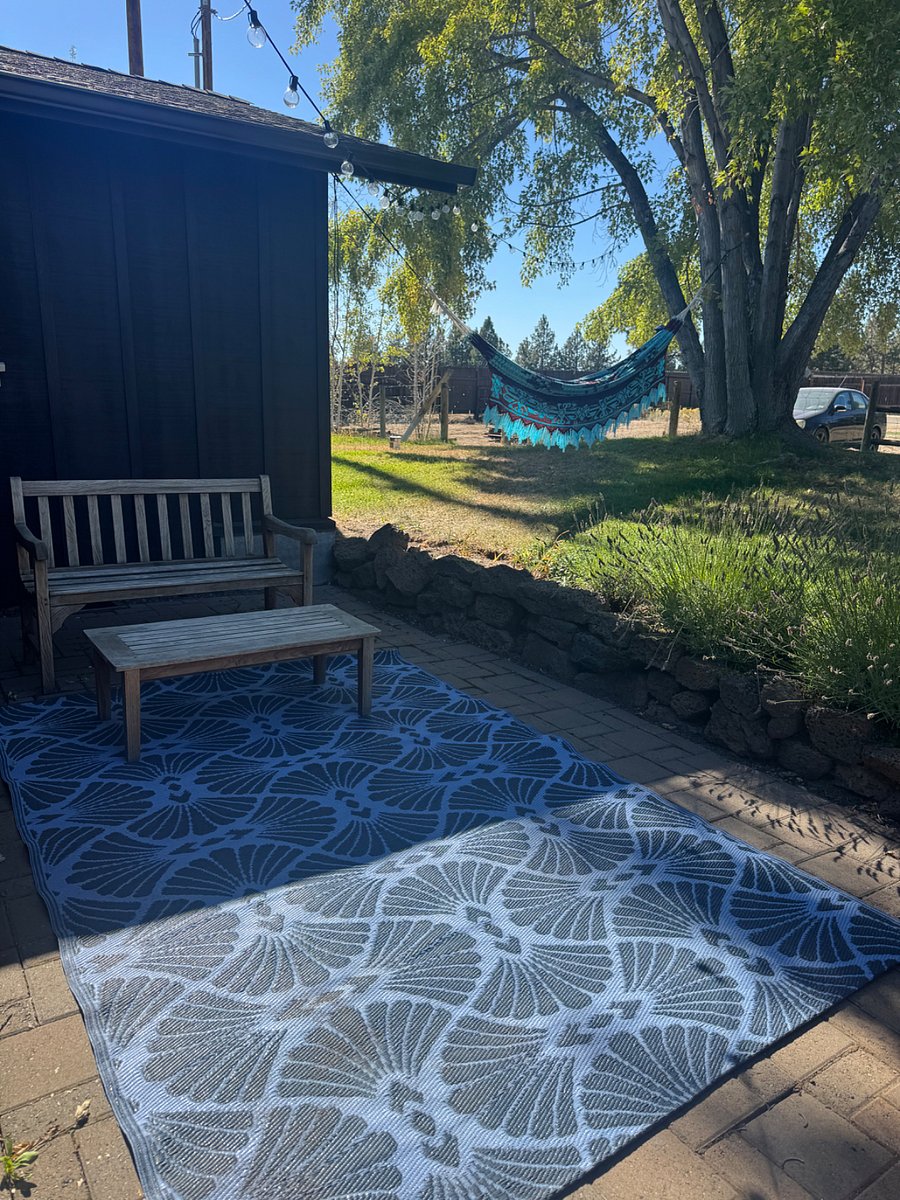 Relaxing back patio and back yard, with big trees.