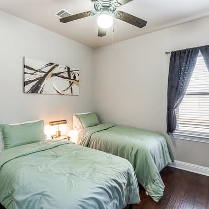 Guest room 2 with two twin beds, tv and walk-in closet